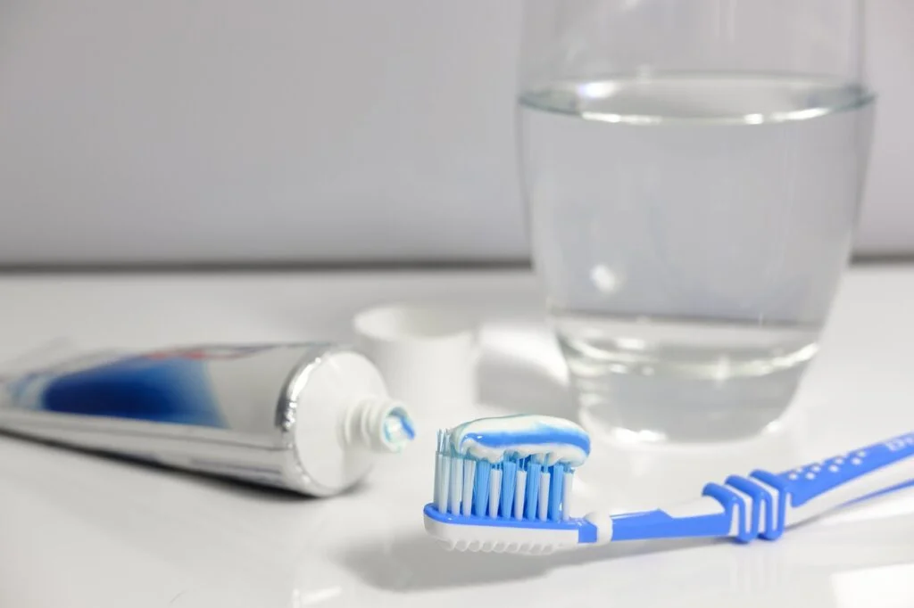 Toothbrush with toothpaste and a glass of water. Self-care for Depression.