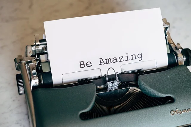 'Be Amazing' on paper from a typewriter. Motivational quote to put on your Canva Vision Board.